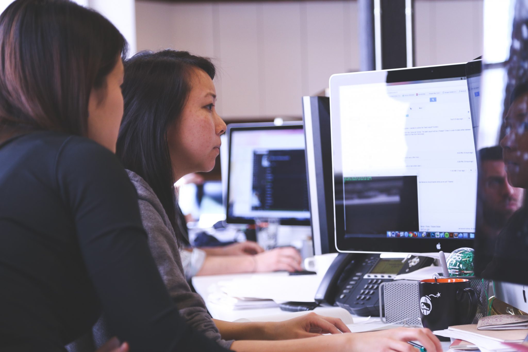 Two young women working together on a project at a computer